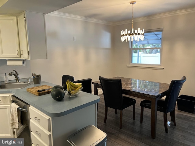 dining space featuring crown molding, dark hardwood / wood-style floors, a chandelier, and sink