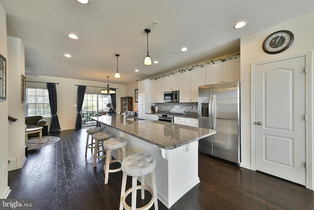 kitchen featuring appliances with stainless steel finishes, white cabinets, a kitchen island with sink, and dark hardwood / wood-style floors