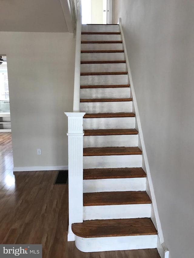 stairway with hardwood / wood-style flooring and ceiling fan