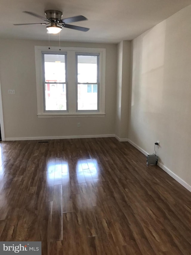 spare room featuring ceiling fan and dark wood-type flooring