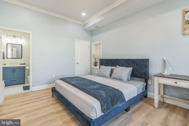 bedroom featuring ornamental molding, light hardwood / wood-style flooring, and ensuite bath