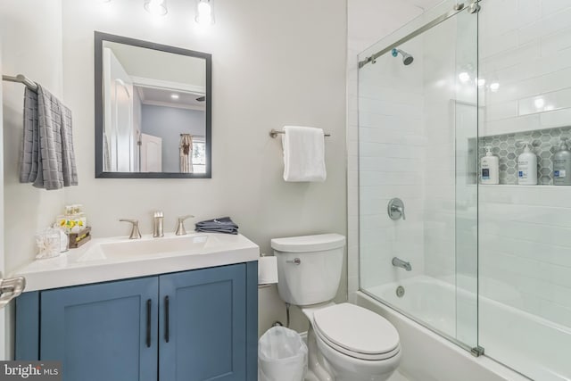 full bathroom featuring combined bath / shower with glass door, vanity, and toilet