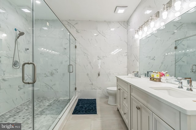 bathroom featuring vanity, tile patterned floors, toilet, walk in shower, and tile walls