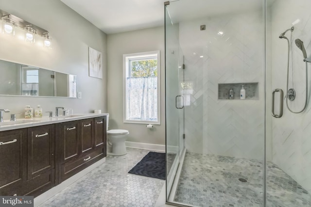 bathroom featuring tile patterned flooring, vanity, an enclosed shower, and toilet