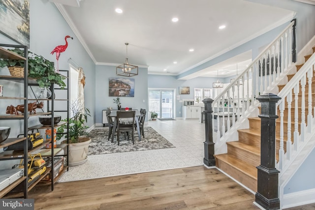 dining room with hardwood / wood-style floors, ornamental molding, and a notable chandelier