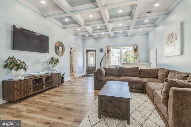 living room with a high ceiling, coffered ceiling, light hardwood / wood-style flooring, beamed ceiling, and ornamental molding