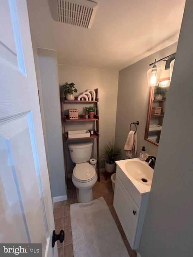 bathroom featuring toilet, vanity, and tile patterned flooring