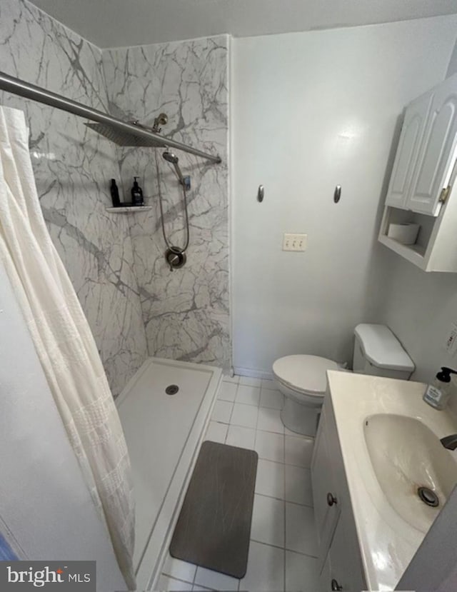 bathroom featuring vanity, toilet, tile patterned floors, and a shower with curtain