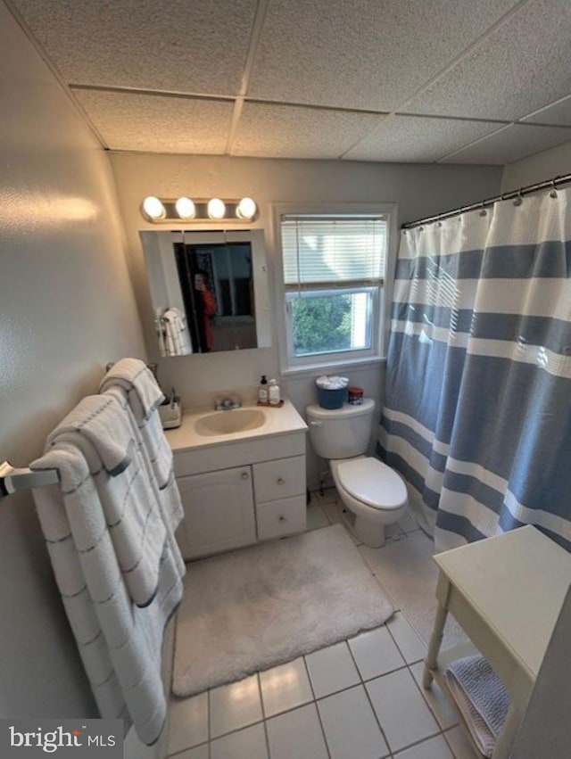 bathroom featuring vanity, toilet, a paneled ceiling, and tile patterned flooring