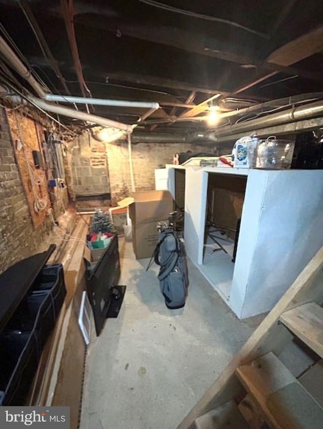 basement featuring brick wall