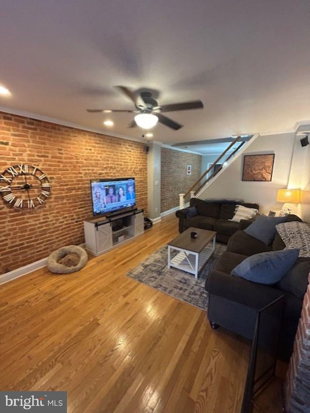 living room with ceiling fan, brick wall, and wood-type flooring