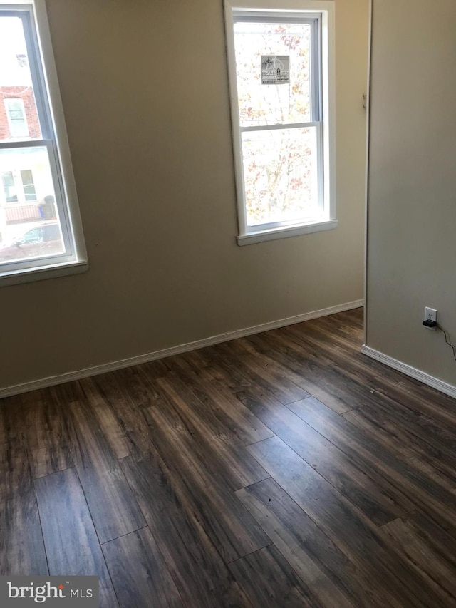 spare room featuring dark wood-type flooring