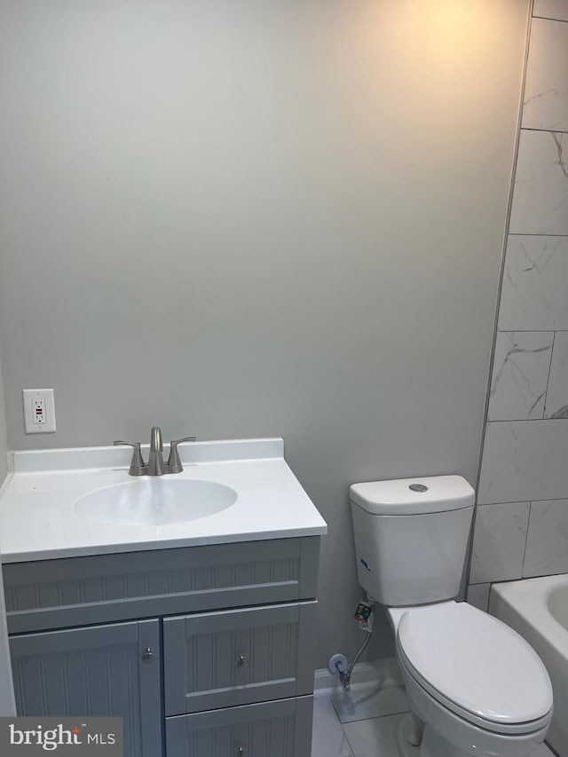 bathroom with vanity, toilet, and a washtub