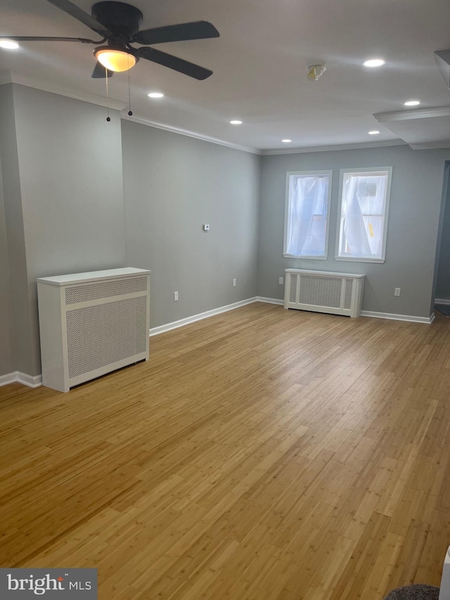 empty room with ornamental molding, light hardwood / wood-style flooring, radiator heating unit, and ceiling fan