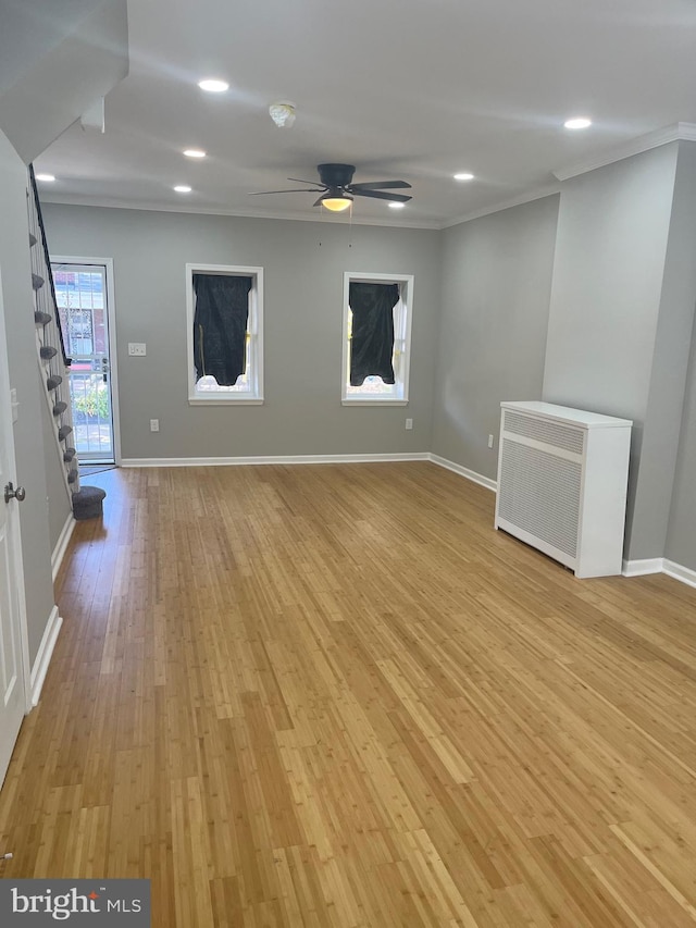 interior space with ornamental molding, light hardwood / wood-style flooring, radiator, and ceiling fan