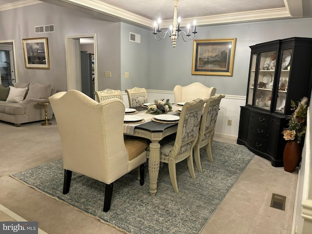 dining space with ornamental molding, light colored carpet, a chandelier, and a textured ceiling