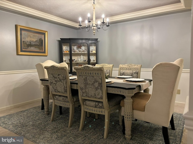 dining area with crown molding, an inviting chandelier, and a textured ceiling