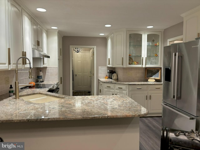 kitchen featuring light stone counters, sink, dark hardwood / wood-style flooring, white cabinetry, and stainless steel fridge with ice dispenser