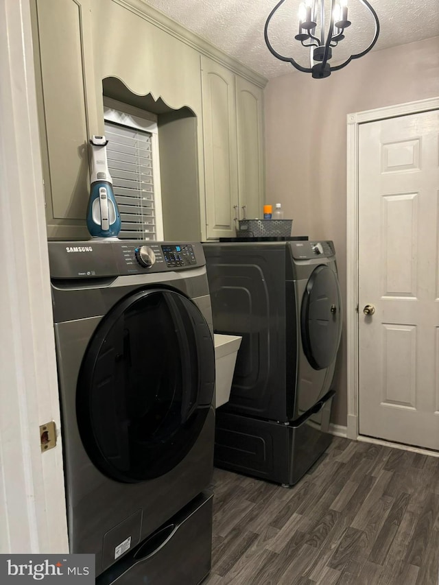 washroom featuring cabinets, a textured ceiling, dark wood-type flooring, and washing machine and clothes dryer