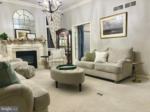 carpeted living room with a stone fireplace, an inviting chandelier, and ornamental molding