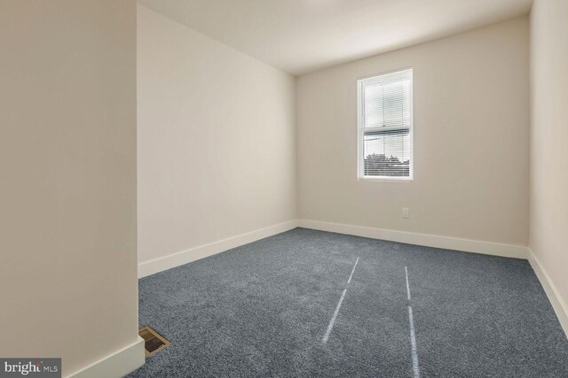 empty room with dark colored carpet