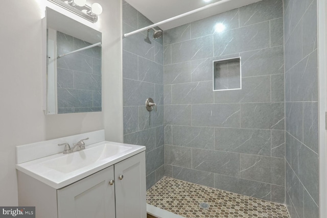 bathroom with vanity and a tile shower