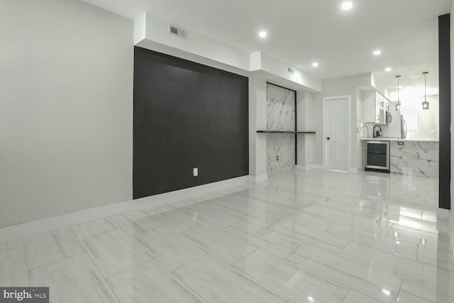 unfurnished living room featuring beverage cooler