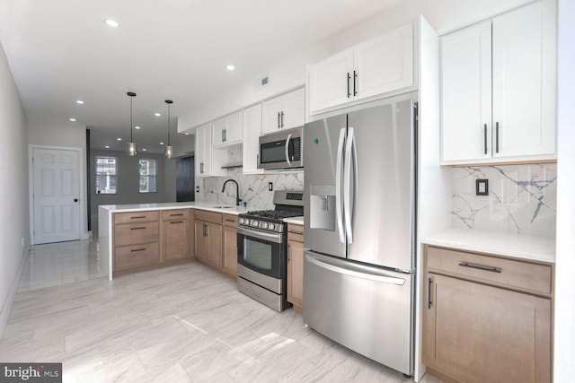 kitchen featuring white cabinetry, appliances with stainless steel finishes, pendant lighting, and decorative backsplash