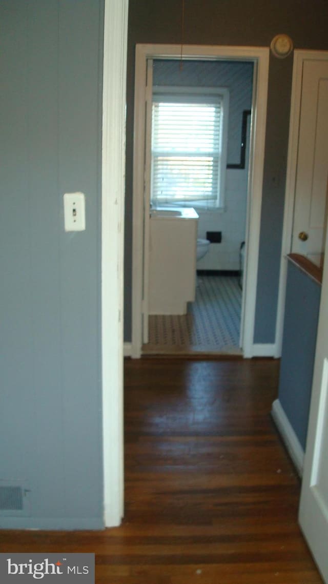 hallway with dark hardwood / wood-style flooring