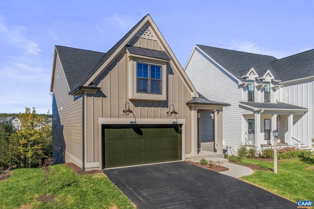 view of front facade featuring a garage, a front lawn, and a porch