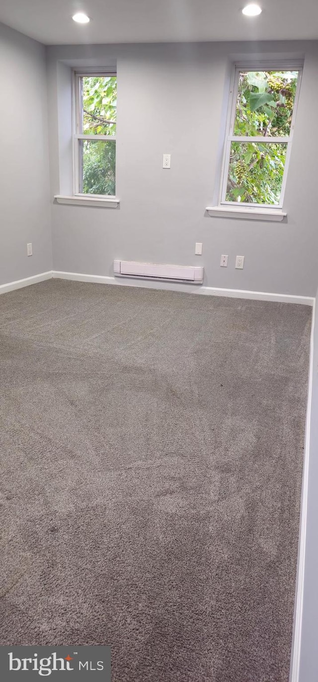 spare room featuring baseboard heating and carpet flooring