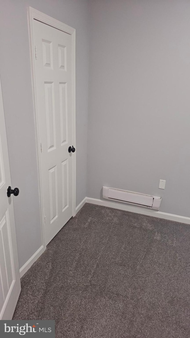 carpeted empty room with baseboard heating