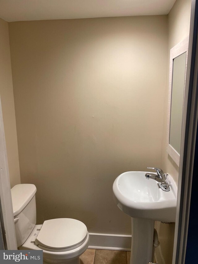 bathroom with toilet and tile patterned flooring