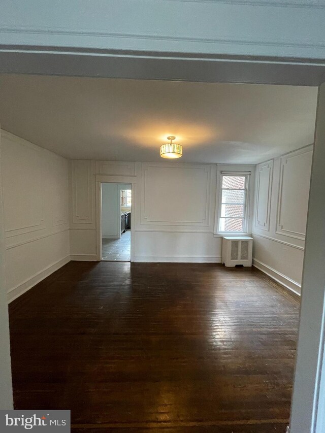 unfurnished room featuring dark wood-type flooring