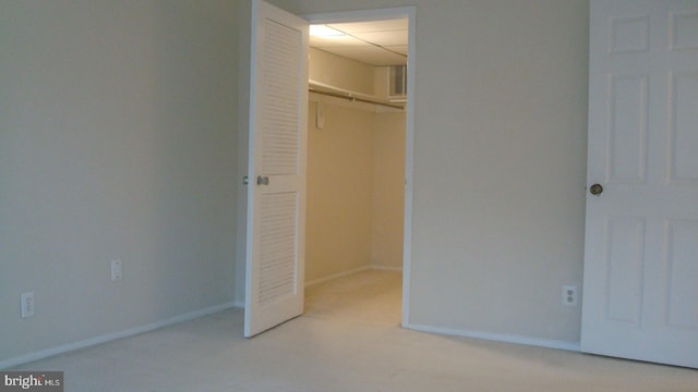 unfurnished bedroom featuring light carpet and a closet