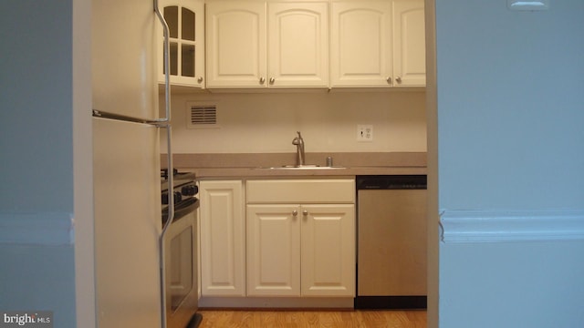 kitchen with white cabinetry, light wood-type flooring, white appliances, and sink