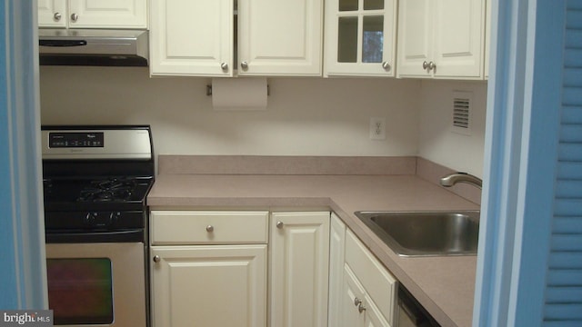 kitchen with white cabinetry, sink, and range with gas cooktop