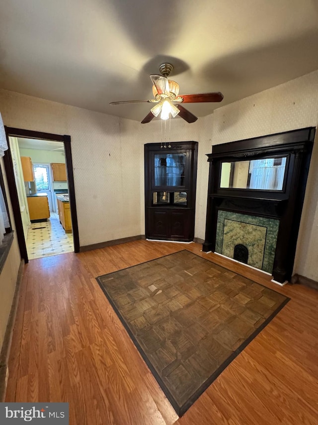 unfurnished living room with ceiling fan and hardwood / wood-style floors