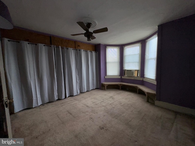 spare room with cooling unit, light colored carpet, and ceiling fan