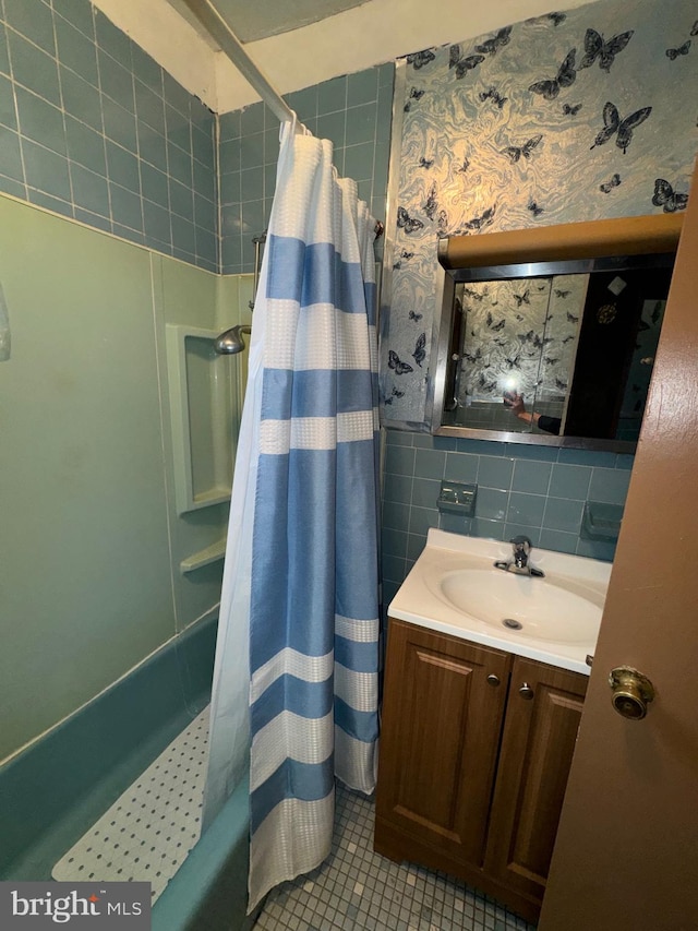 bathroom featuring vanity, tile patterned flooring, tile walls, and shower / tub combo