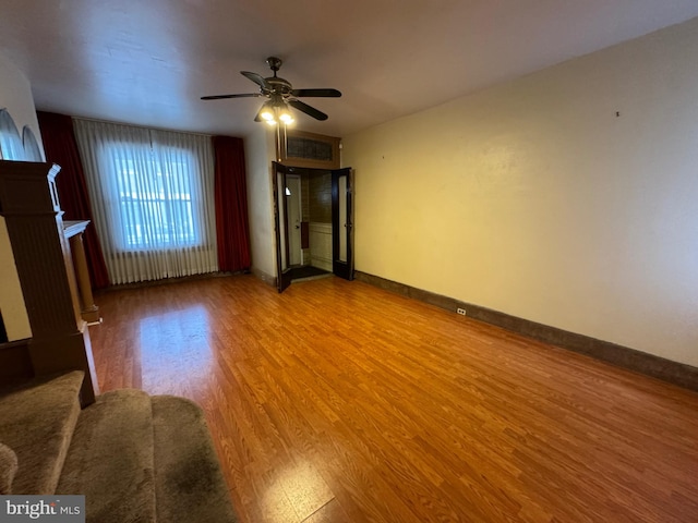 unfurnished living room featuring hardwood / wood-style floors and ceiling fan