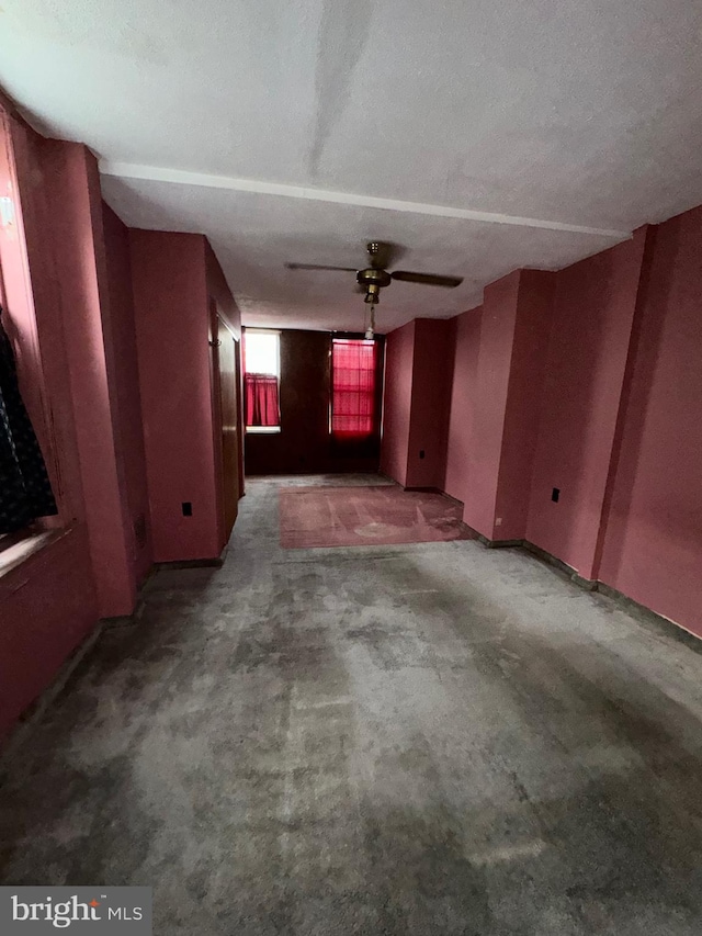 spare room featuring dark carpet, a textured ceiling, and ceiling fan