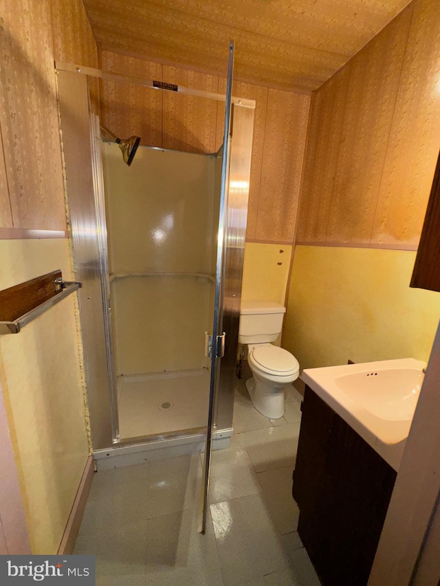 bathroom featuring vanity, an enclosed shower, and toilet