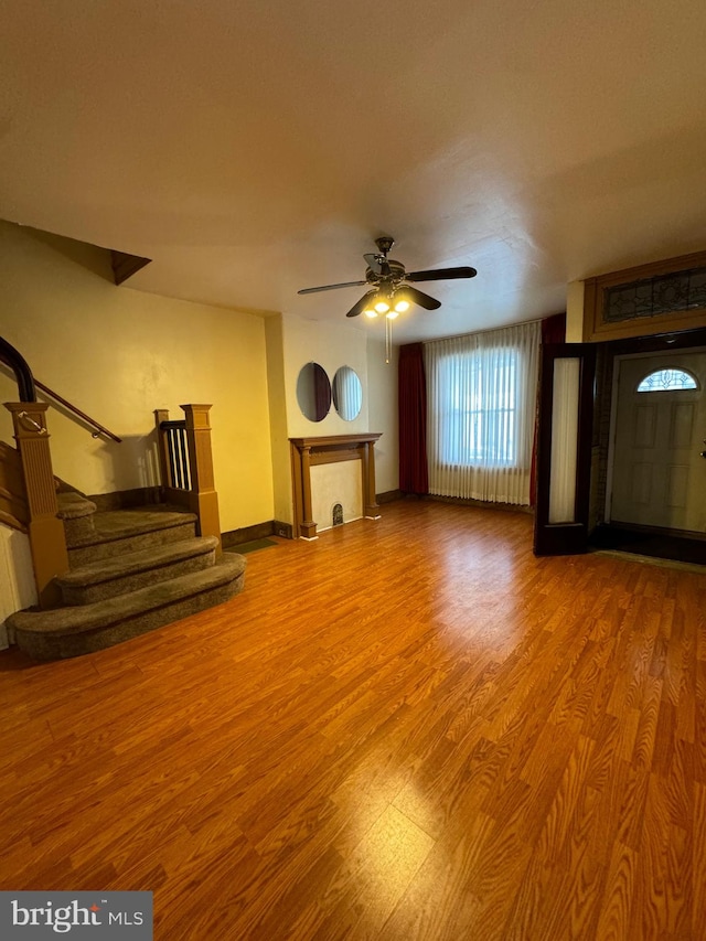 unfurnished living room featuring hardwood / wood-style flooring and ceiling fan