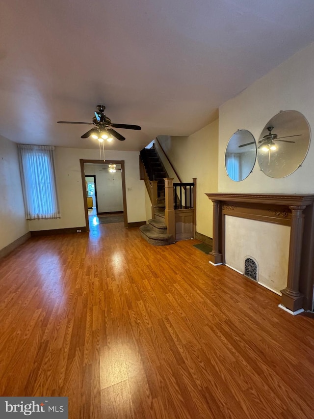 unfurnished living room with ceiling fan and hardwood / wood-style floors