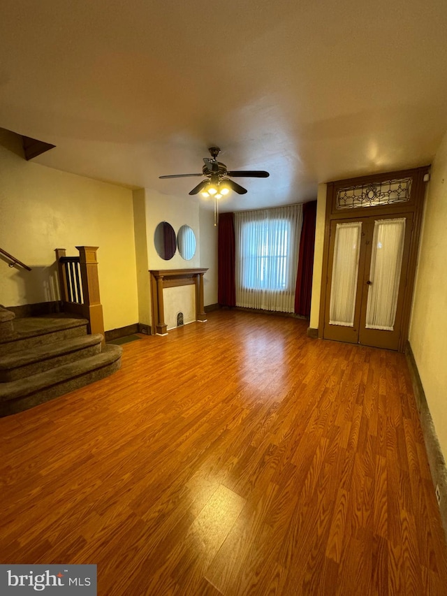 unfurnished living room with hardwood / wood-style flooring and ceiling fan