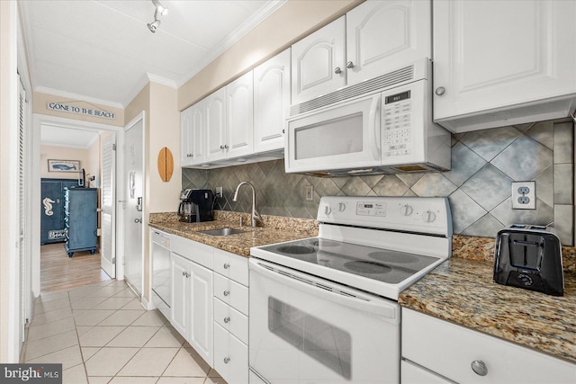 kitchen with white appliances, dark stone countertops, white cabinetry, and sink