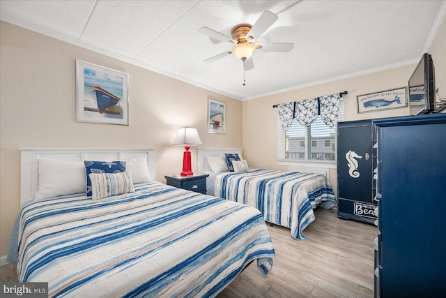 bedroom featuring light hardwood / wood-style flooring, crown molding, and ceiling fan