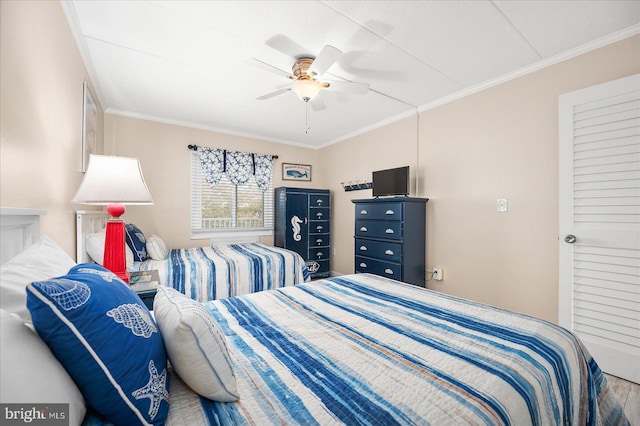 bedroom with ornamental molding, hardwood / wood-style floors, and ceiling fan