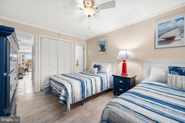 bedroom with ornamental molding, a closet, light wood-type flooring, and ceiling fan